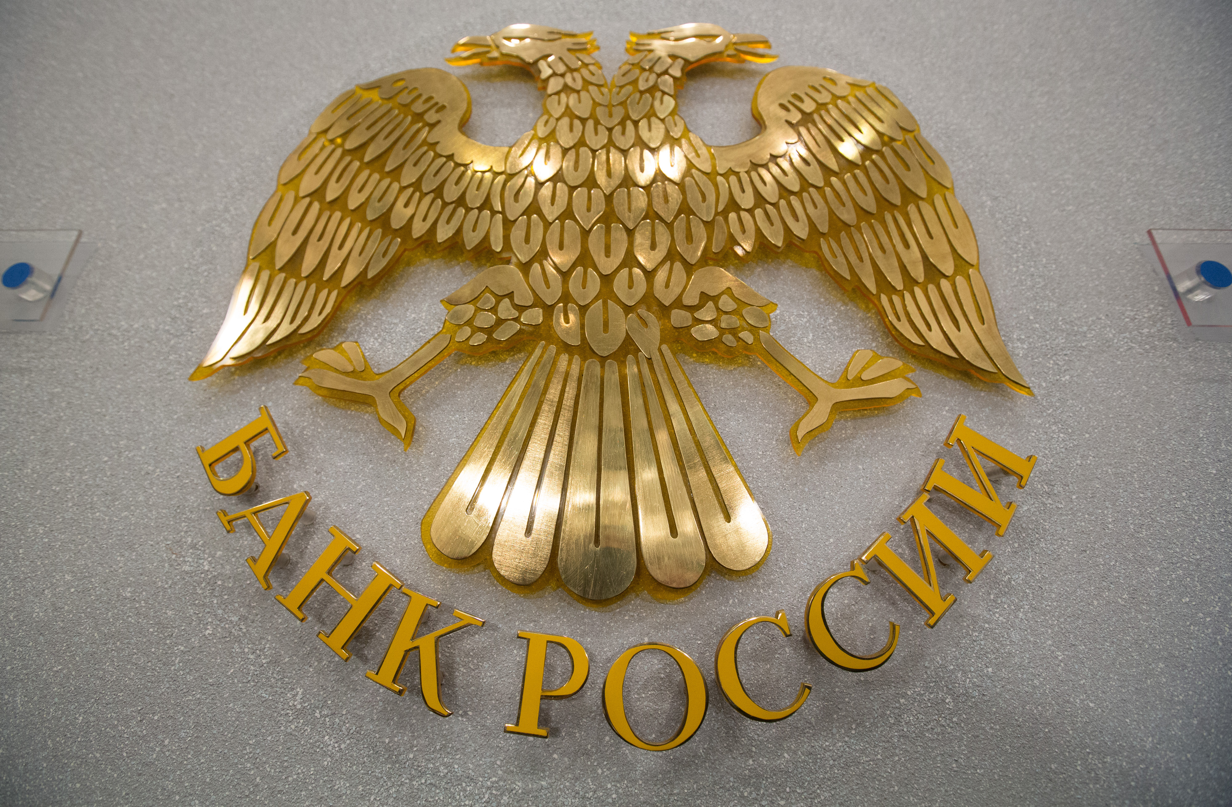 The seal of the Russian Central bank, also known as Bank Rossii, sits on display in Moscow, Russia, on Friday, March 13, 2015. Russia&#39;s central bank lowered its main interest rate in line with most economist forecasts, as stabilizing inflation clears the path to boosting an economy buckling under low oil prices and sanctions over Ukraine. Photographer: Andrey Rudakov/Bloomberg